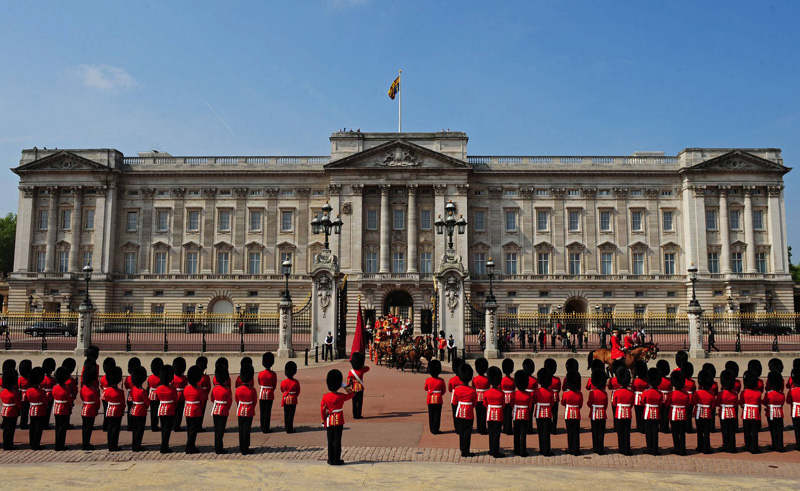 A troca real acontece na frente do palácio de Buckingham, em Londres.