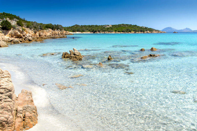 Água cristalina de Spiaggia di Petra Ruja na Sardenha.